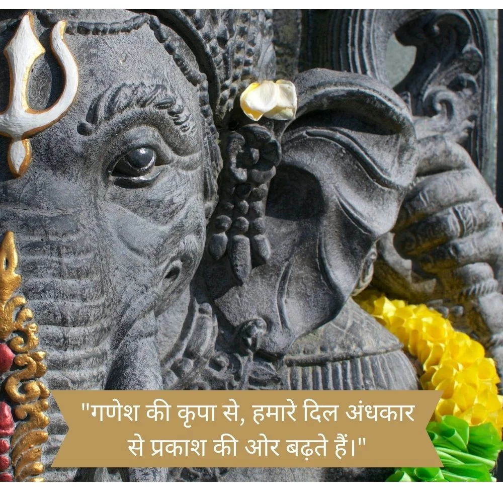 Grey colour face stachu of ganesh ji displayed, beautiful tikka and yellow with green colour flowers