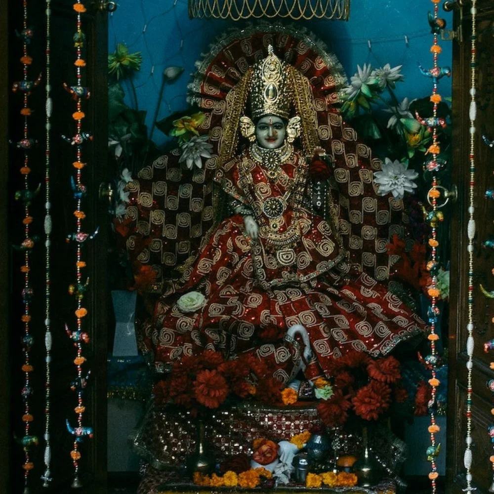 stauch wearing the red clothes, left and right a garland of flowers is set