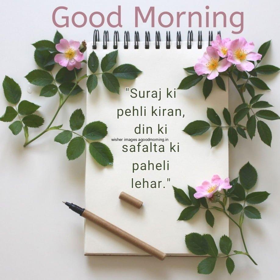 pink flowers with green leaf notebook is placed in center, good morning quote, unique motivational quote