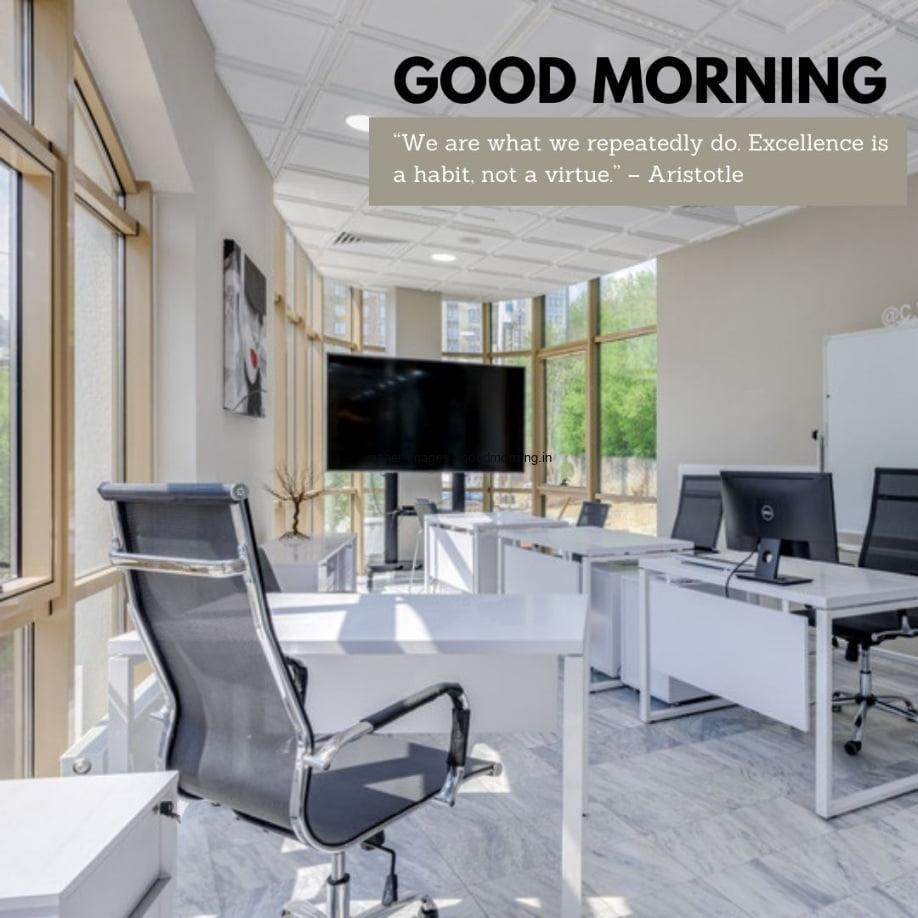 White office area, multiple deck with monitors on table, outside area is visible , good morning quote is placed