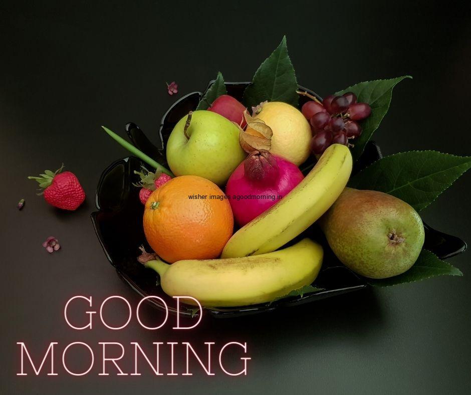 Black background with orange,banana, mango, strawberry in bowl good morning image text colour red with white border