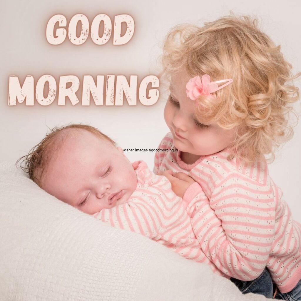 Brown girl sleeping and his sister see the baby wearing the grey background is setup good morning quote is placed