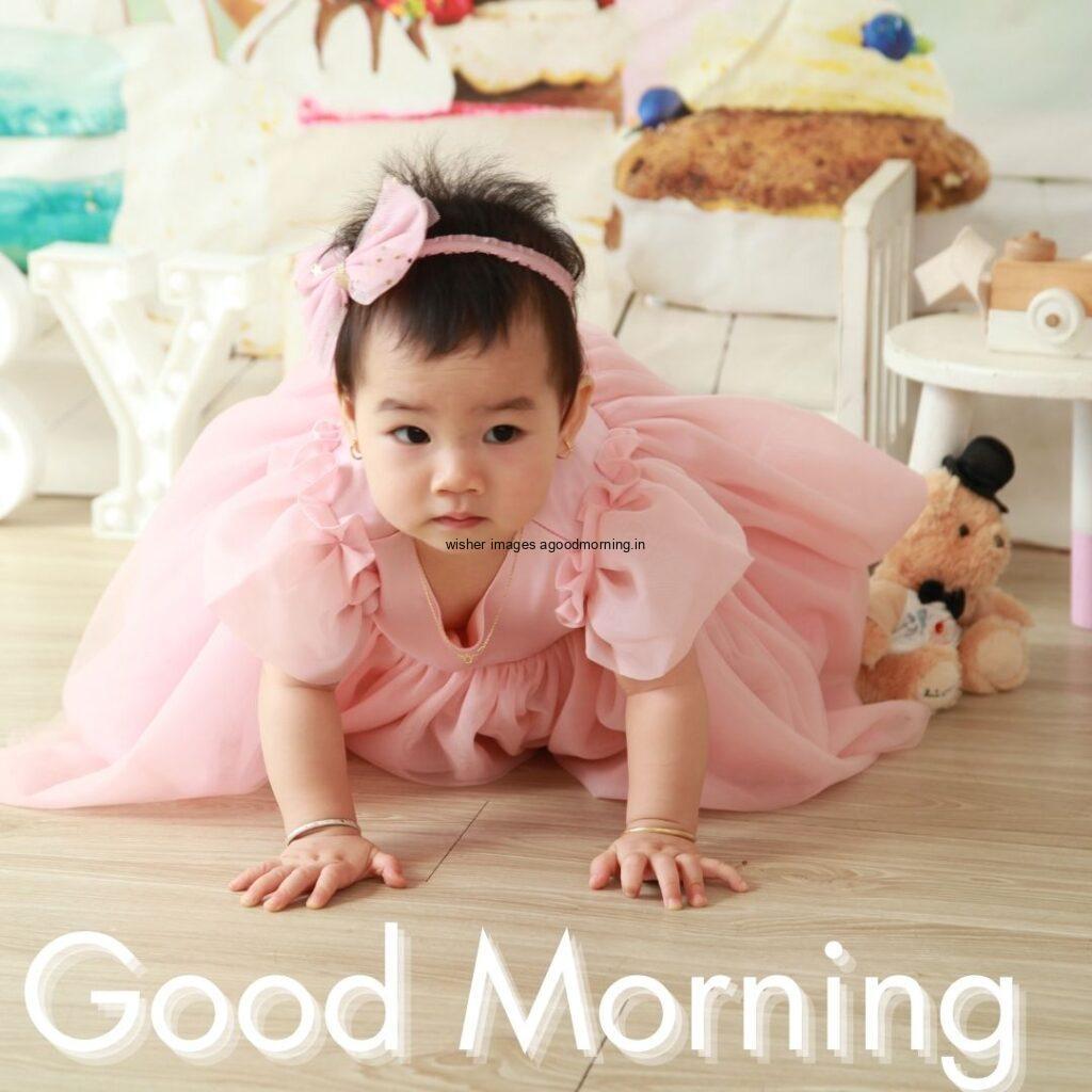 Good morning quote is placed, baby girl sitting in room and wearing the pink dress