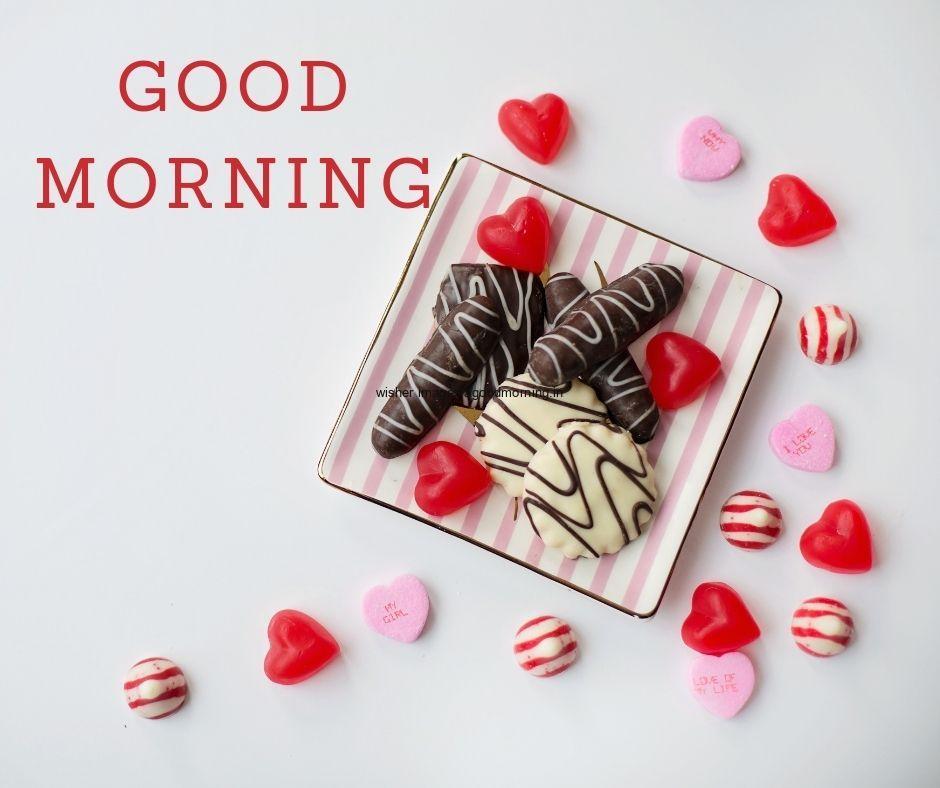 Grey background is placed with red candy good morning quote is placed with red