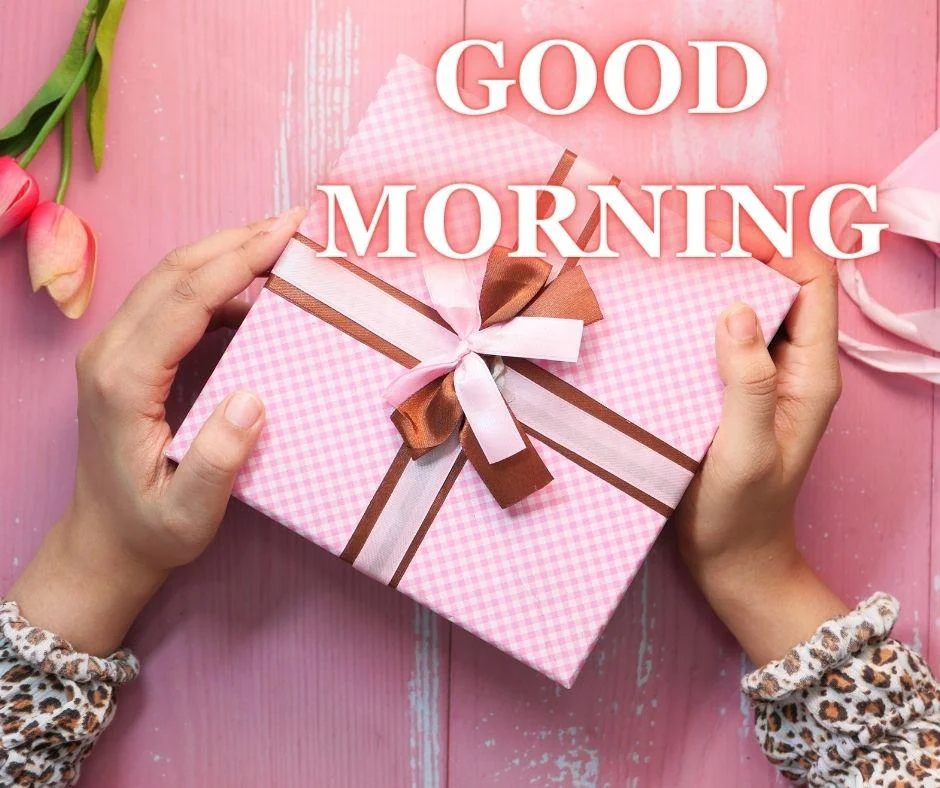 Pink background with pink box open with lady hand good morning images with golden text