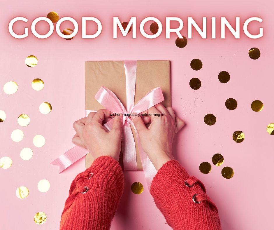 Pink colour background with breautiful Lady hand open the brown colour gift boxes, with pink ribbon good morning images box