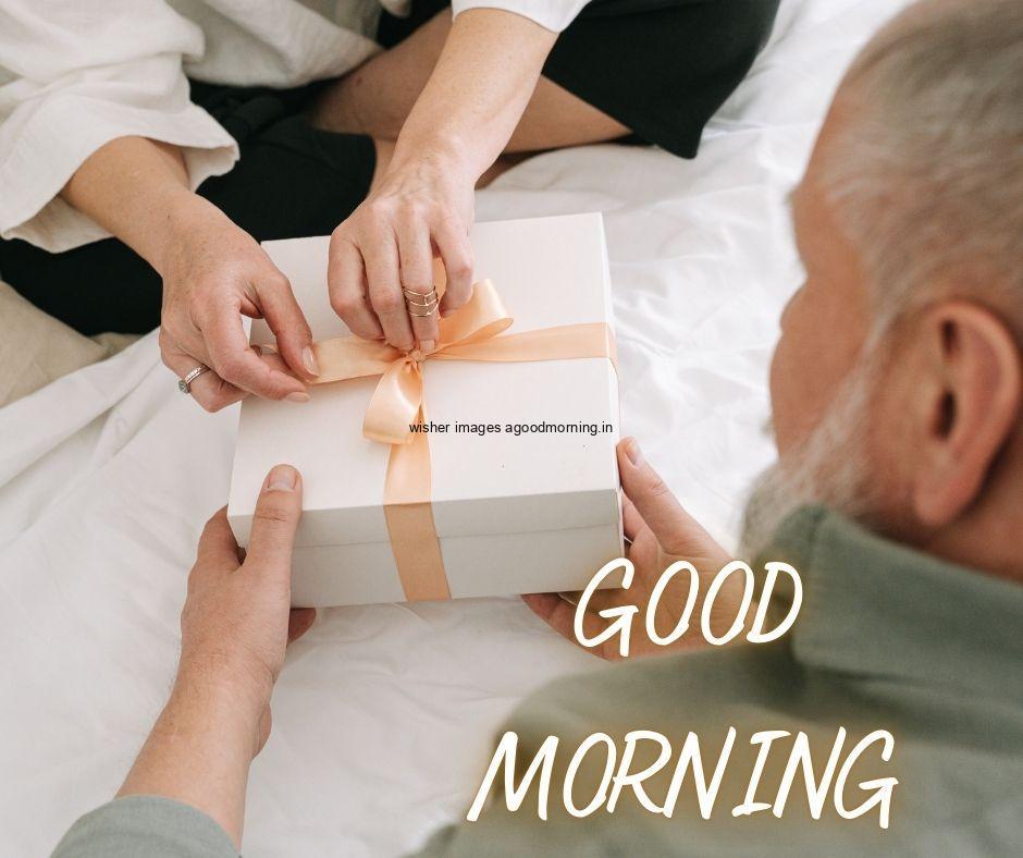 Two-hand-holding-the-white-gift-box-with-golden-ribbon-good-morning-image 69+ Good Morning Images With Gift Boxes