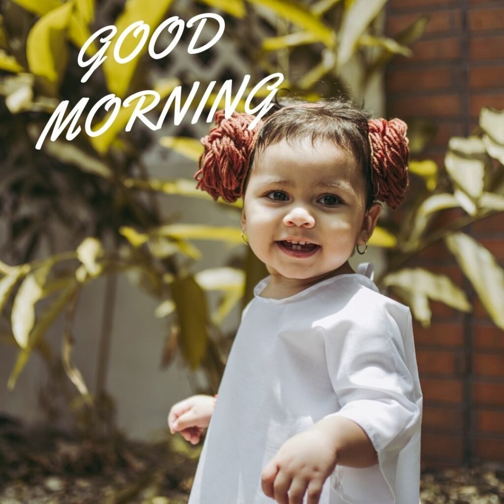 Baby girl is smile nad see backward background feel with leaf good morning quote is placed