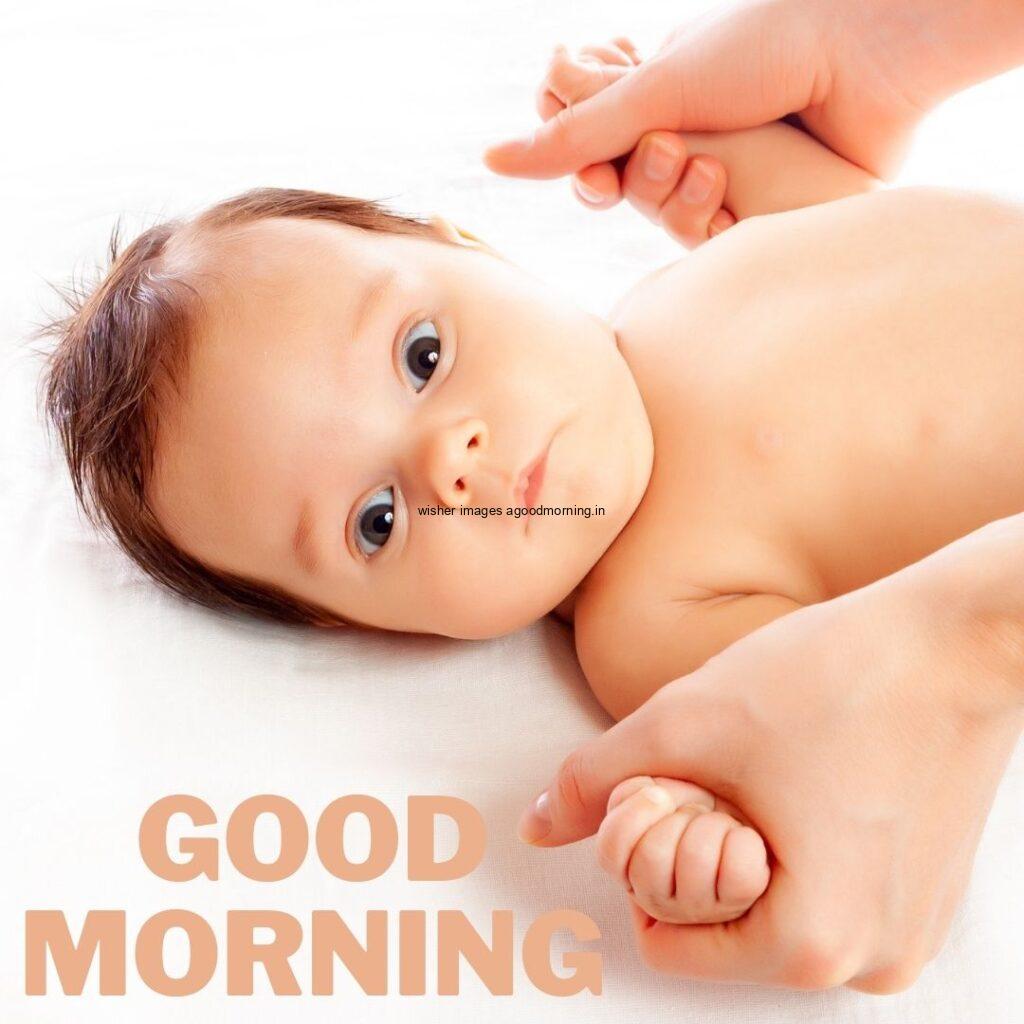 Baby girl seen in front and the girl eye color is black good morning quote is placed