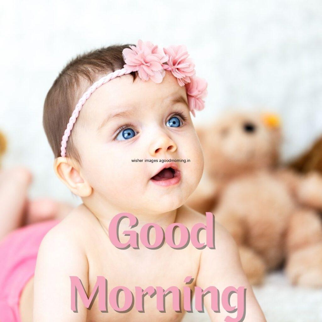 Baby girl seen top and waer the band on the bed, the girl eye colour is blue good morning quote is placed