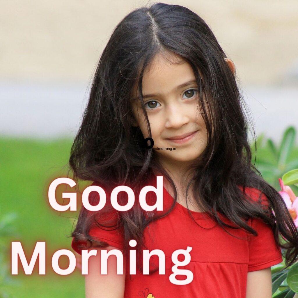 Baby girl wearing the red dress with green background setup good morning quote is placed