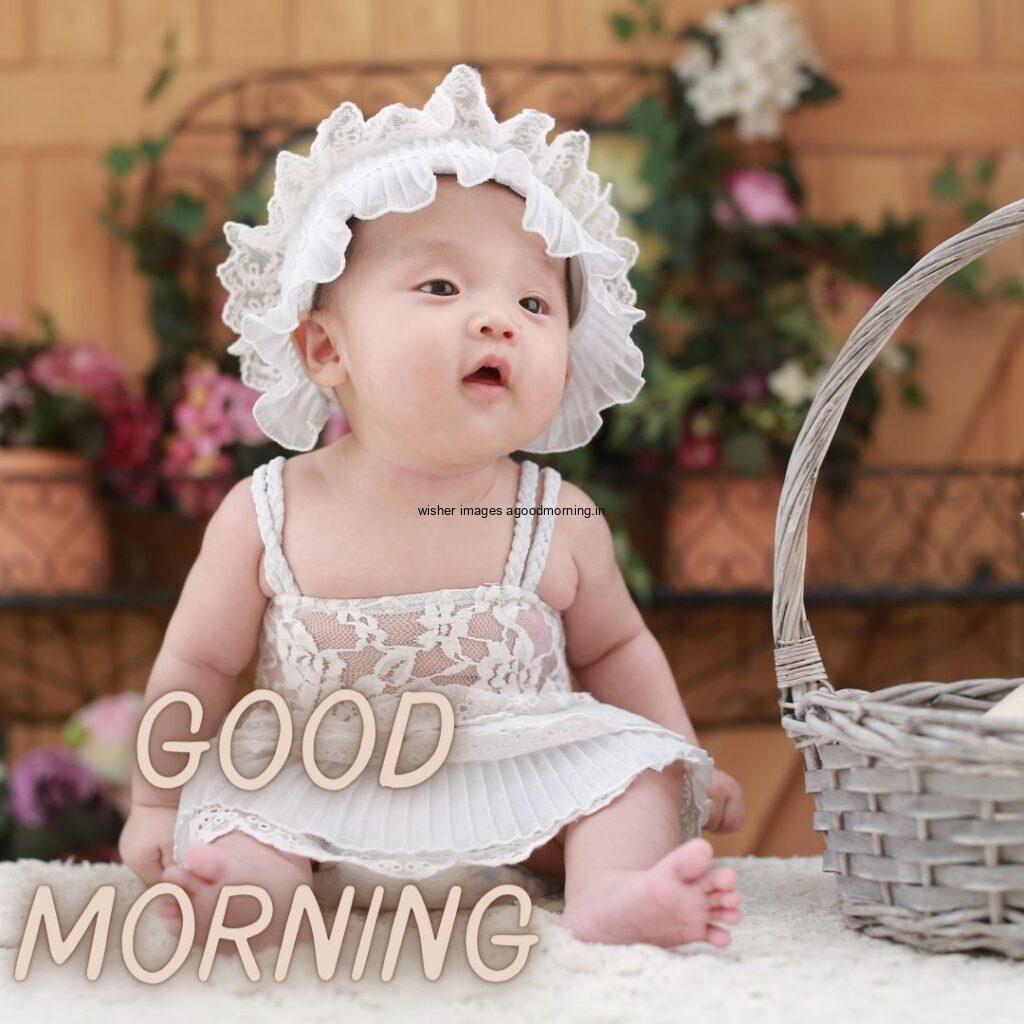 Baby girl white dress wearing with grey basket is placed, good morning quote