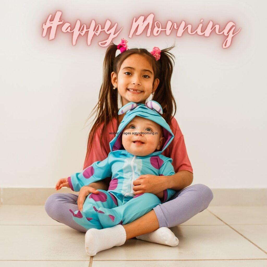 Baby with girl is sitting together, behind the grey background is setup, good morning quote is placed