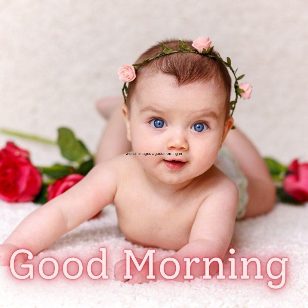 Behind the rose is placed baby girl seen top and waer the band on the bed, the girl eye colour is blue good morning quote is placed