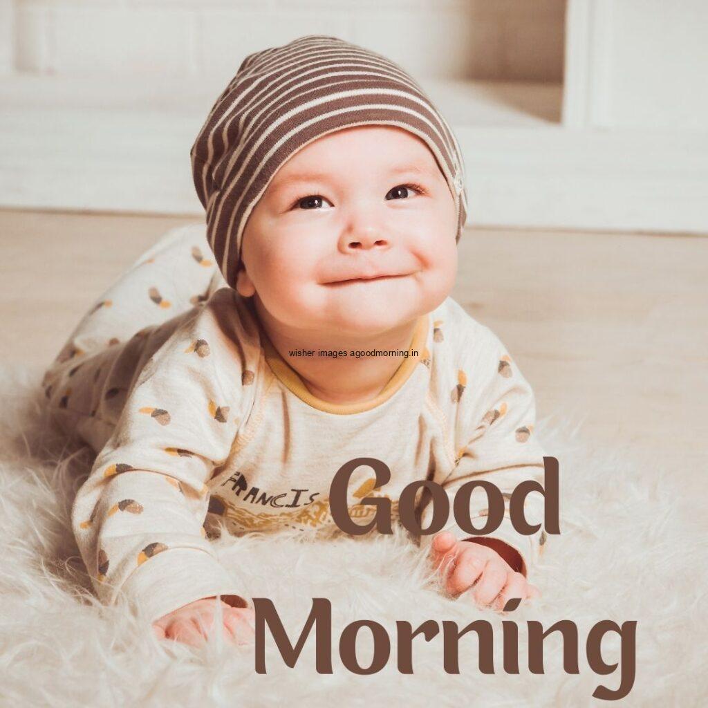 Smile baby seen in front and light brown dress is wearing good morning quote is placed