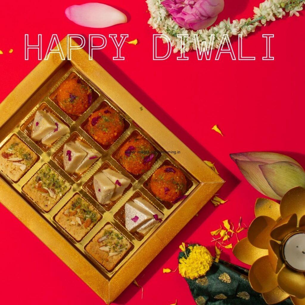 dark yellow background colourful diya & sweet with flowers happy diwali image