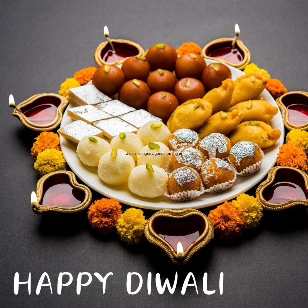 diya with sweets combine with flowers grey background with happy diwali image